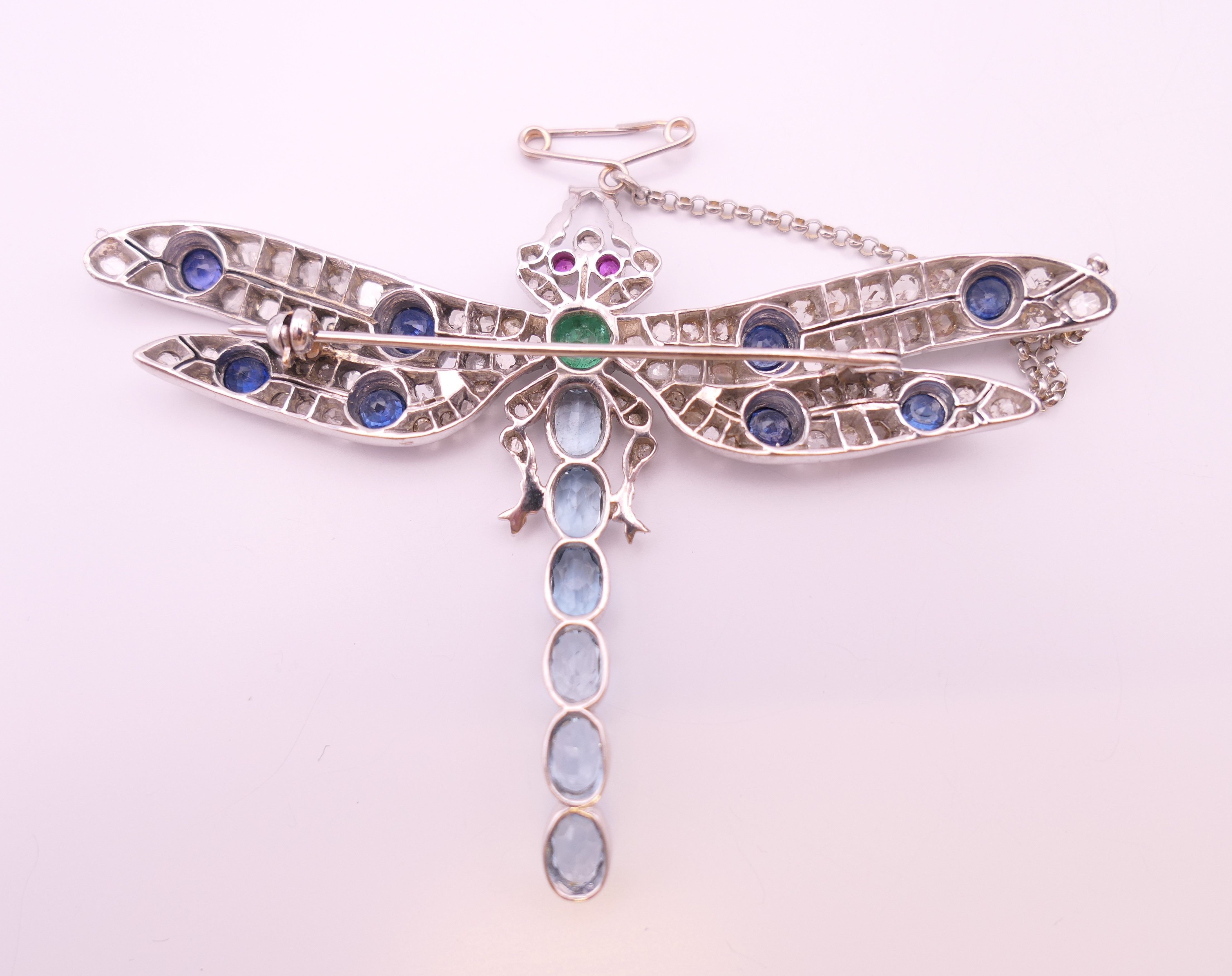 An unmarked 18 ct white gold dragonfly form diamond, sapphire, ruby, emerald and aquamarine brooch. - Image 6 of 11