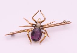 A 9 ct gold opal and amethyst spider form brooch. 6 cm long. 5.9 grammes total weight.