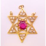 An unmarked gold Burmese ruby and seed pearl star form pendant. 4.5 cm high. 11.