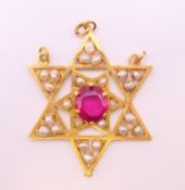 An unmarked gold Burmese ruby and seed pearl star form pendant. 4.5 cm high. 11.