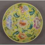 A Chinese porcelain yellow ground saucer,