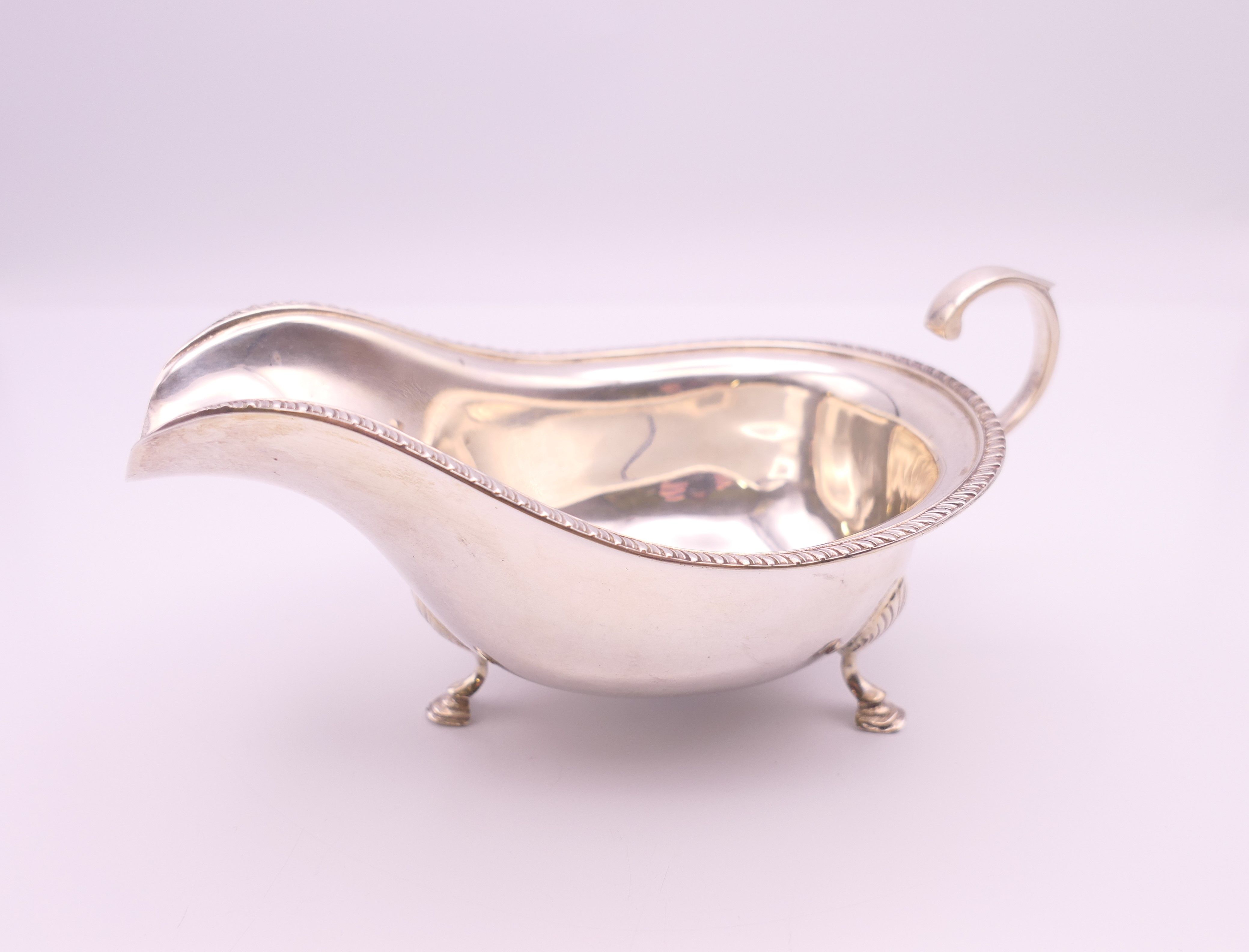 A silver sauceboat. 6.5 cm high x 15 cm long. 103.8 grammes.