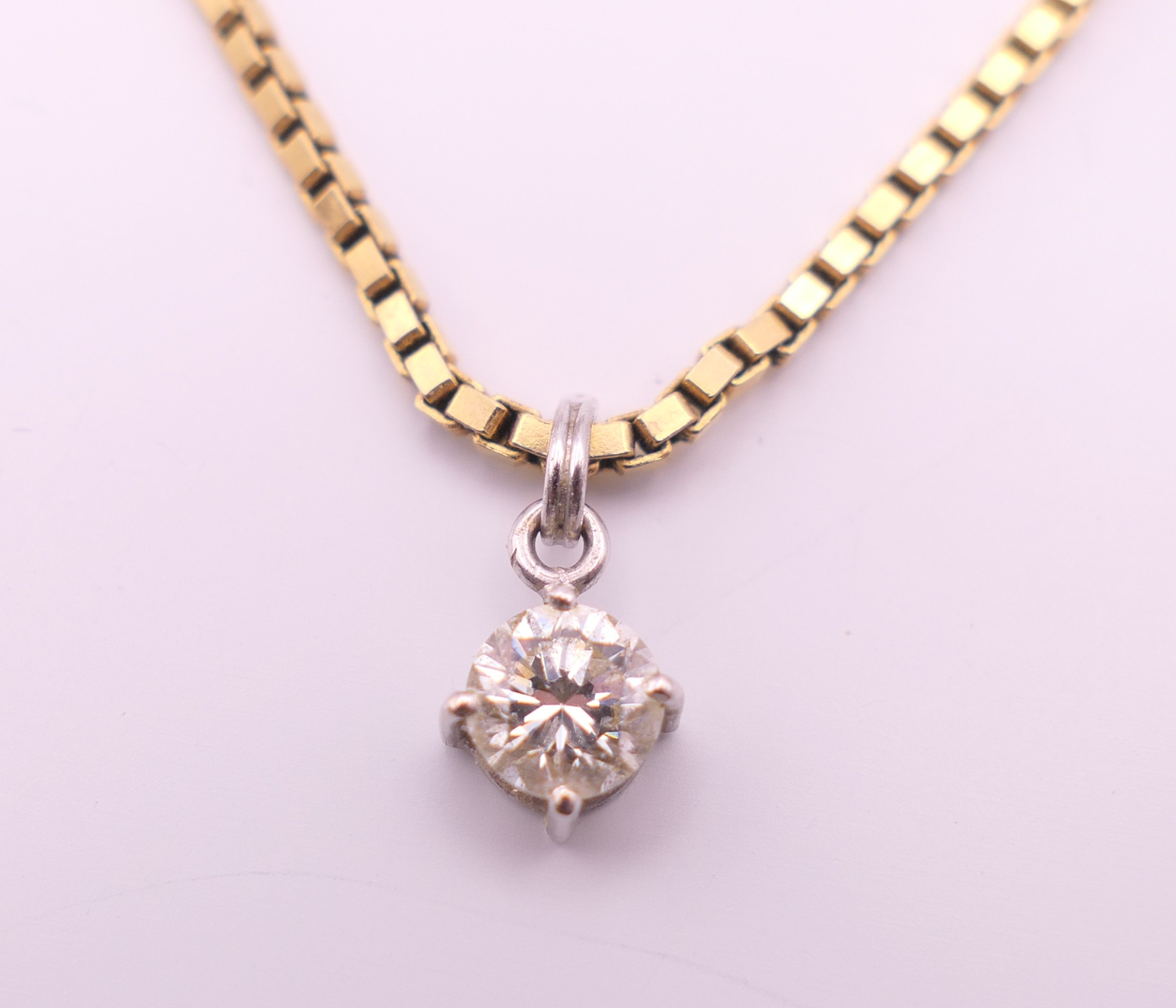 A diamond pendant on a 9 ct gold chain. Pendant 0.5 cm diameter, chain 40 cm long. 5. - Image 2 of 5