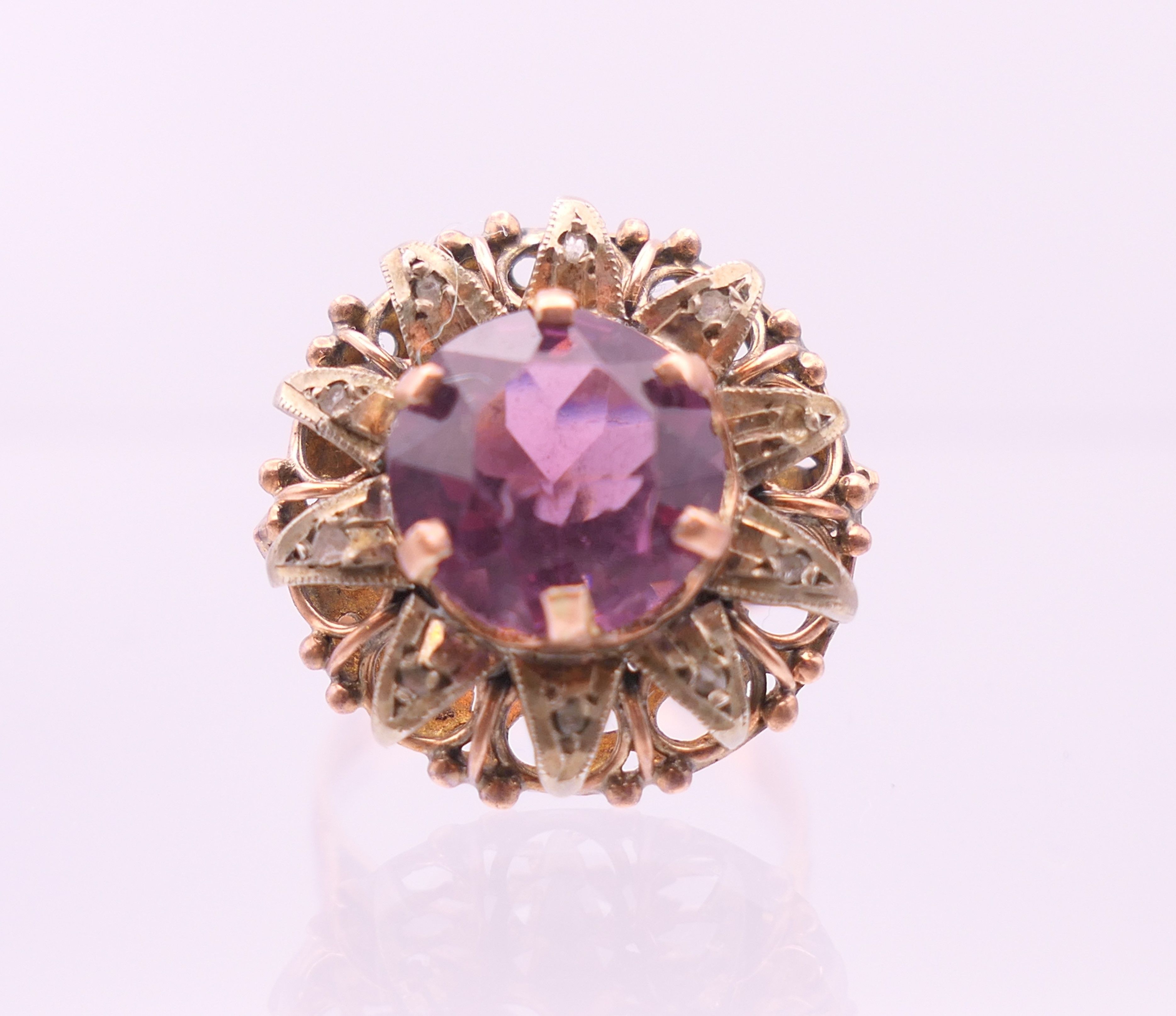 A 9 ct gold, amethyst and diamond flowerhead ring. Ring size Q.