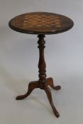 A Victorian inlaid walnut games table. 45 cm diameter.
