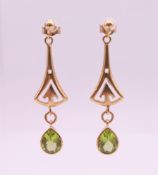 A pair of 9 ct gold and peridot drop earrings. 4 cm high. 4.9 grammes total weight.