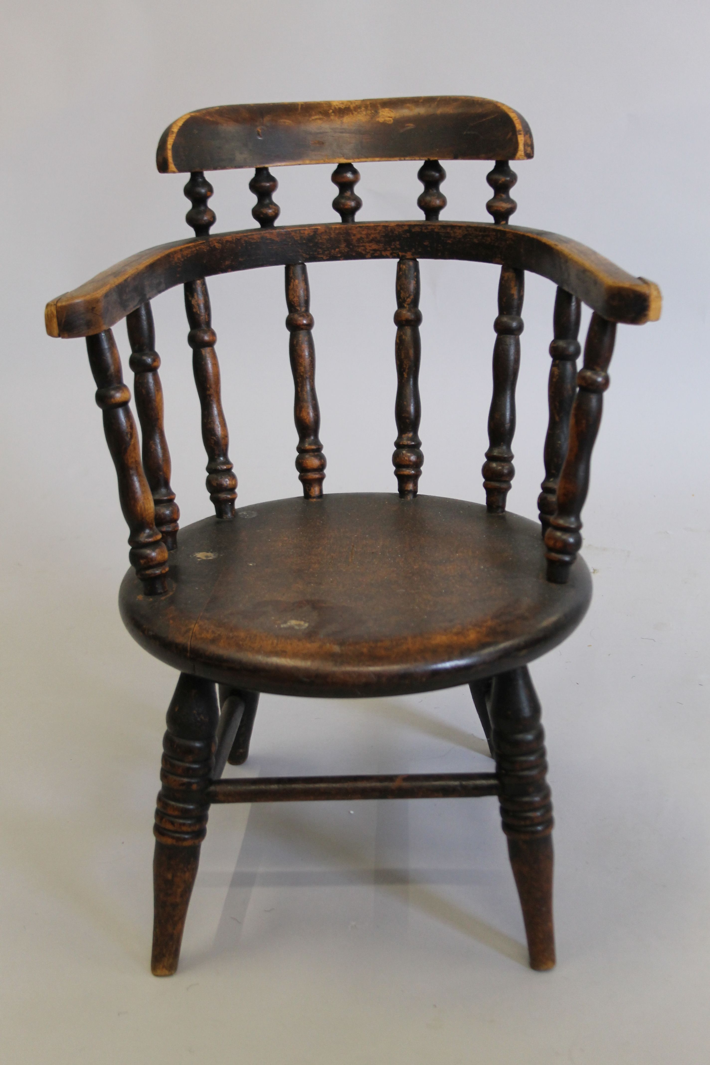 A Victorian child's smokers bow armchair. 36.5 cm wide.