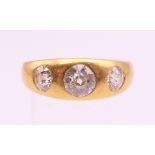 An 18 ct gold three stone diamond ring. The central stone spreading to approximately .75 carat.