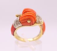 An 18 K gold coral and diamond double dolphin/duck head ring. Ring size M/N.