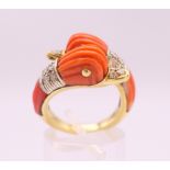 An 18 K gold coral and diamond double dolphin/duck head ring. Ring size M/N.