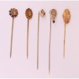 Five various diamond set stickpins. Largest 6.5 cm long.