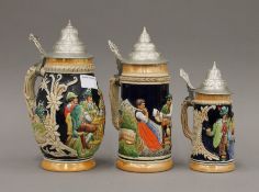 Three pottery lidded steins. The largest 23 cm high.