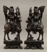 A pair of late 19th/early 20th century Chinese hardwood carvings depicting Guanyin riding a deer.