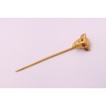 A 9 ct gold and ruby bulls head form stick pin. 5.75 cm high. 1.7 grammes total weight.