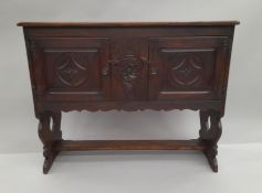 A carved oak side cupboard. 107 cm wide.