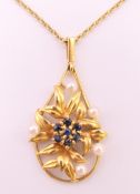 A 9 ct gold sapphire and pearl pendant on a 9 ct gold chain.