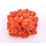 A profusely carved coral brooch. 5.5 x 5.5 cm.