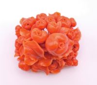 A profusely carved coral brooch. 5.5 x 5.5 cm.
