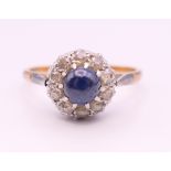 An 18 ct gold and platinum cabochon sapphire and diamond cluster ring. Ring size Q.
