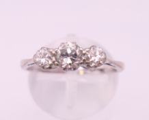 A platinum three stone diamond ring. Ring size P.