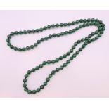 A string of malachite beads. 92 cm long.