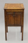 An inlaid oak games cupboard. 39.5 cm squared.