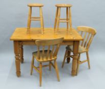 A modern pine table, two pine chairs and two pine stools. The table 121 cm long.
