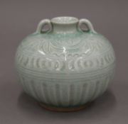 An Oriental celadon glazed vase with incised decoration to the body. 10 cm high.