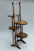 An early 20th century oak folding cake stand. 89 cm high.