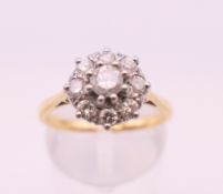 An 18 ct gold diamond flower head ring. Ring size N. 3.8 grammes total weight.