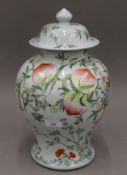 A large Chinese lidded jar painted with peaches, etc., with four character mark to base.