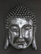 A silvered buddha mask. 58 cm high.