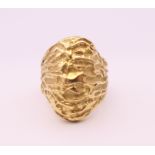 An unmarked gold ring of textured form, probably 18 ct gold. Ring size K/L. 12.8 grammes.