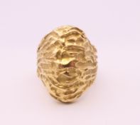 An unmarked gold ring of textured form, probably 18 ct gold. Ring size K/L. 12.8 grammes.