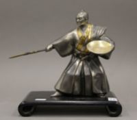 A Japanese model of a samurai on hardwood stand. 25 cm high overall.