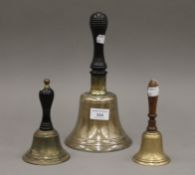 A Victorian ebony handled bell and two others. The former 25.5 cm high.