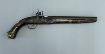 A 19th century Eastern brass inlaid flintlock pistol. 44 cm long.