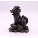 A bronze model of a dog-of-fo on pile of money. 5 cm high.