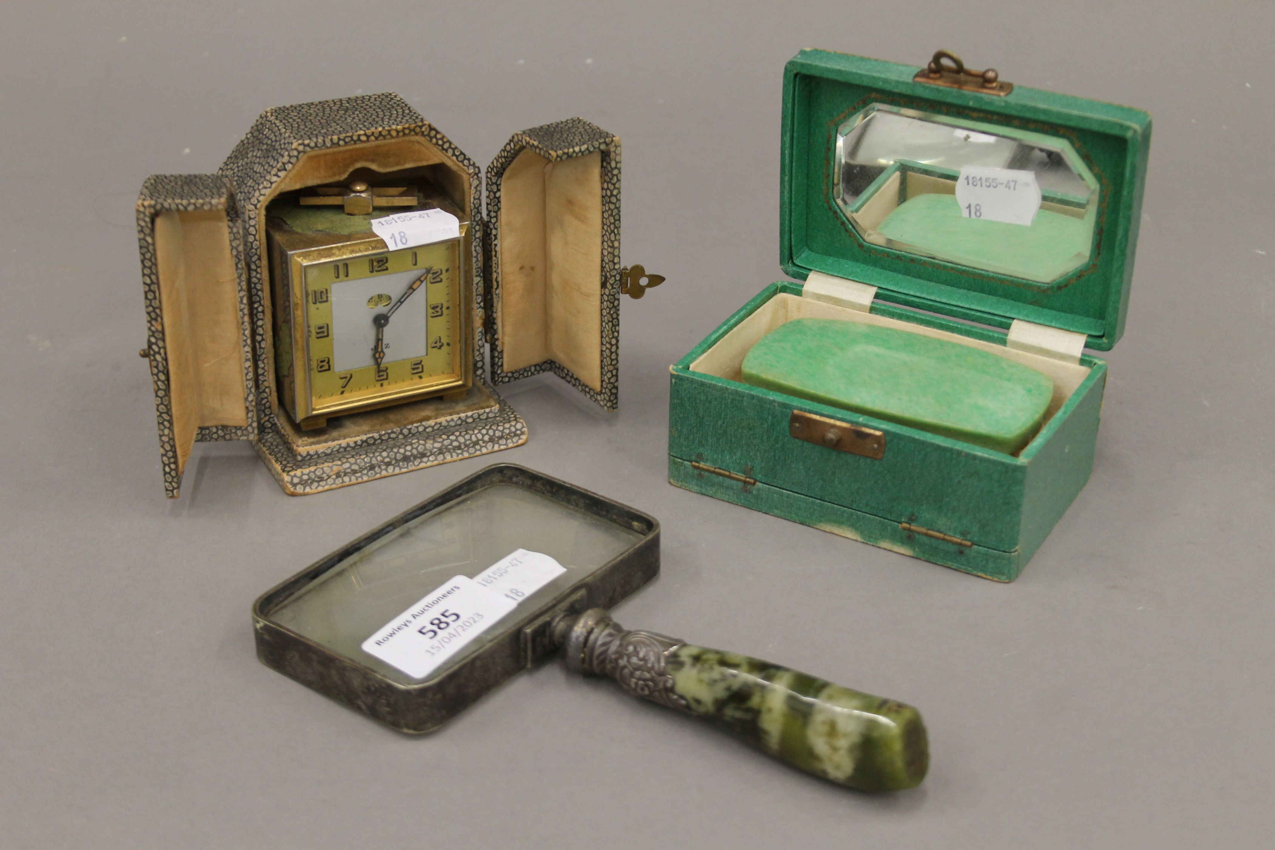 A cased clock, a magnifying glass and a box. The magnifying glass 17 cm long.