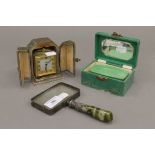 A cased clock, a magnifying glass and a box. The magnifying glass 17 cm long.