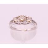 A 10 K white gold three stone diamond ring. Total diamond weight approximately 0.90 carat.