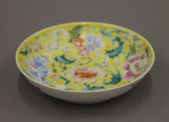 A Chinese porcelain yellow ground saucer,