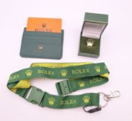 A Rolex lanyard, a Rolex credit card holder wallet and a Rolex lapel pin badge.