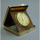 A silver cased travelling clock. 9 cm square.
