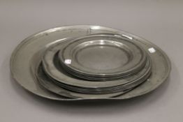 A quantity of antique pewter chargers. The largest 45 cm diameter.