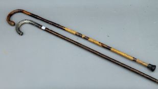 An unmarked silver handled walking stick and another.