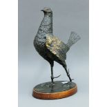 A patinated bronze sculpture of a fighting cock mounted on a wooden plinth base. 39 cm high.