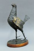 A patinated bronze sculpture of a fighting cock mounted on a wooden plinth base. 39 cm high.