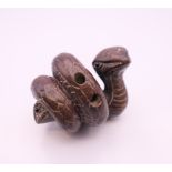 A wooden netsuke formed as a snake. 5 cm wide.