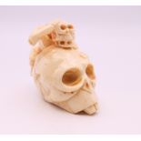 A carved bone netsuke formed as a skull. 4 cm high.